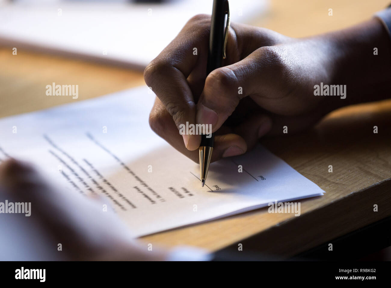 Africa maschio scrivere a mano firma legale su carta aziendale docum Foto Stock