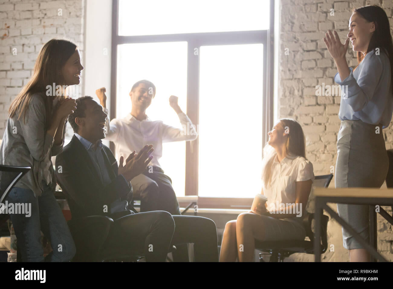 Entusiasta team diversificato la gente applaude per celebrare il successo suppo Foto Stock