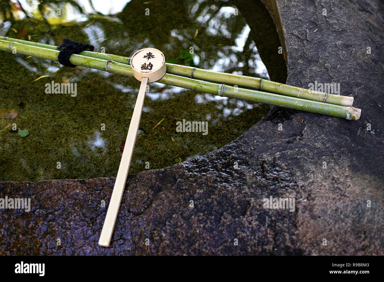 Un mestolo di legno, utilizzato per purfication, appoggia all'entrata di un giardino in uno dei molti templi a Kyoto, Giappone Foto Stock