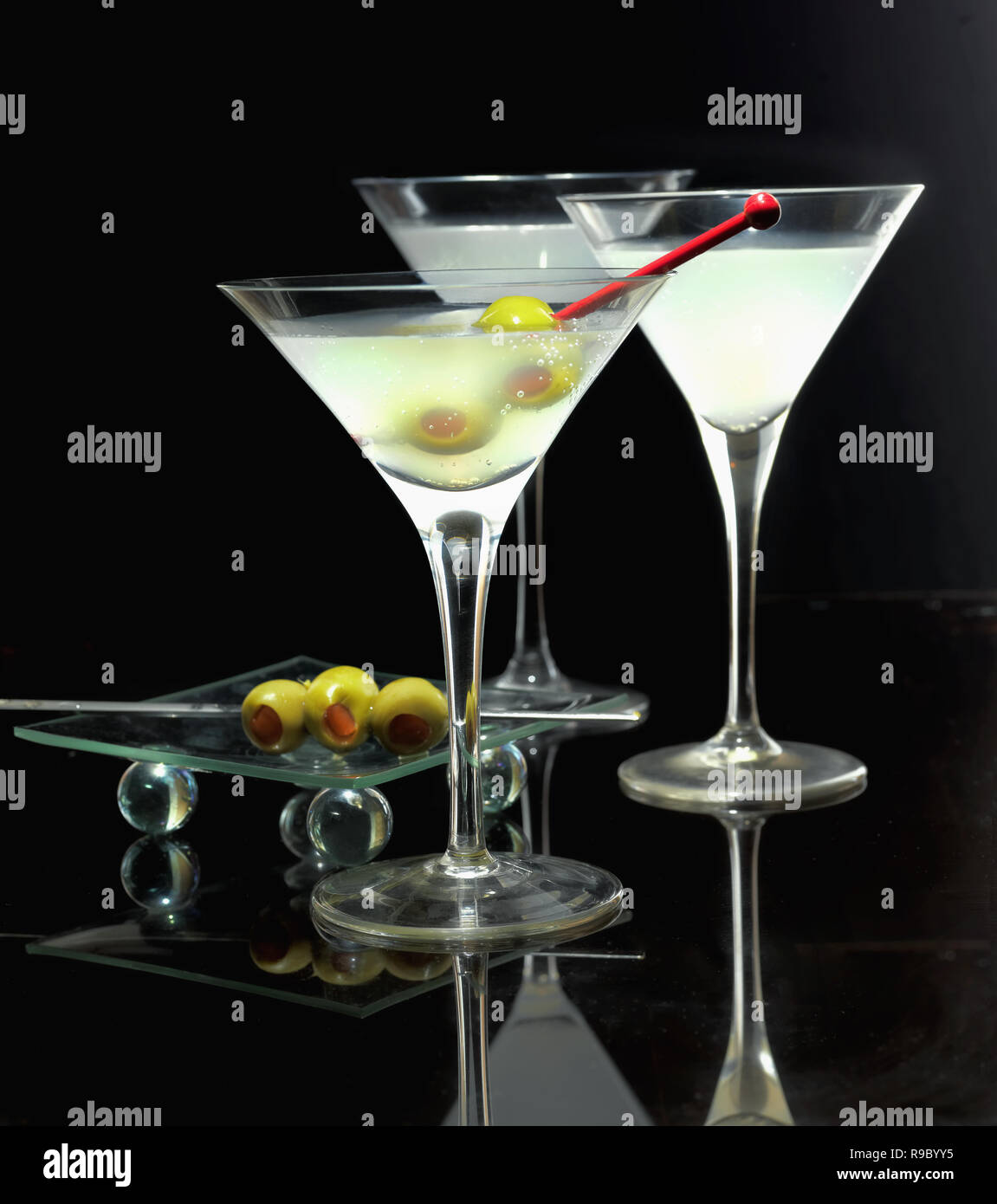 Martini cocktail in wineglasses con olive verdi su sfondo nero Foto Stock