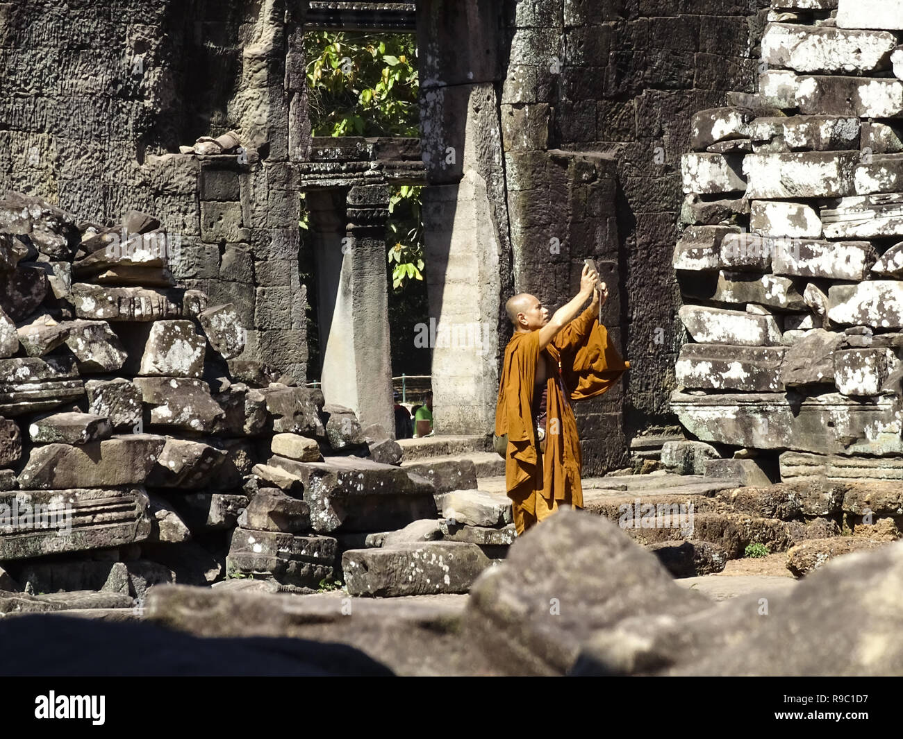 Un monaco buddista è scattare fotografie presso la splendida Angkor Wat in Siem Reap, Cambogia. Foto Stock