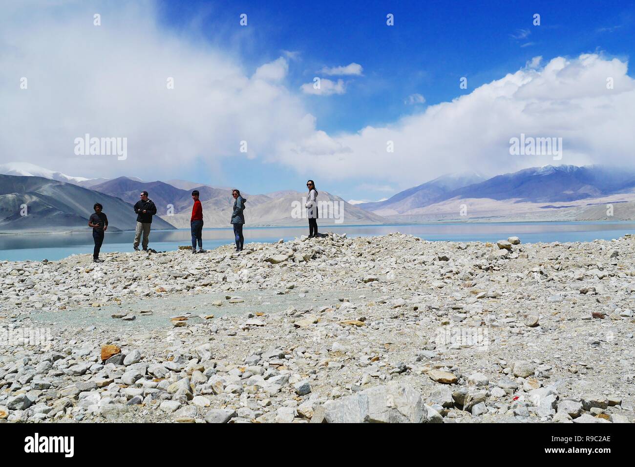 Turisti viaggiano lungo la Karakoram Highway nello Xinjiang Uyghur Regione autonoma, Cina, con lo splendido paesaggio di montagna della Valle dello sfondo. Foto Stock