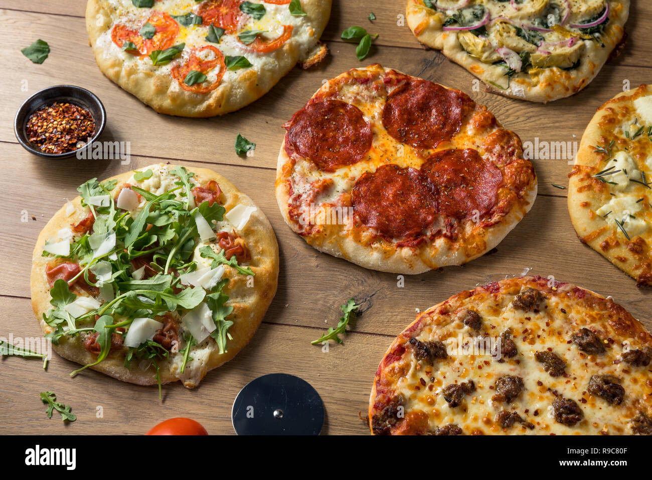 Gourmet assortiti fatti in casa a legna per le pizze con salsiccia per pizza di basilico e formaggio Foto Stock
