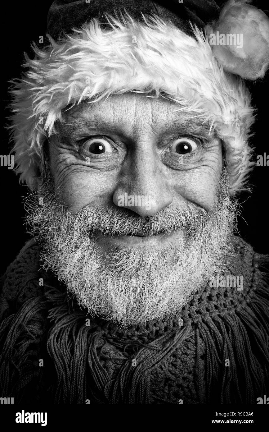 Ritratto in bianco e nero di un uomo adulto con barba bianca mascherata in Babbo Natale per le vacanze di Natale e Capodanno Foto Stock