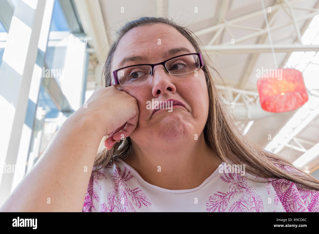 Donna che guarda annoiato, stufi, aveva abbastanza, testa pendente a portata di mano. Concetto di immagine. Foto Stock