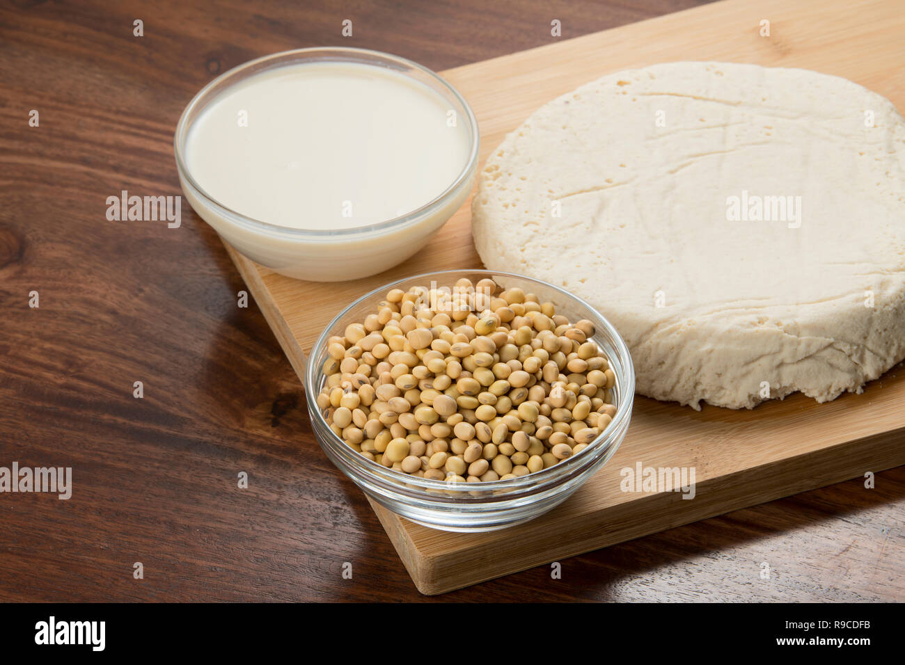 Food : bocce di latte di soia, i fagioli di soia e il tofu isolato su sfondo di legno Foto Stock