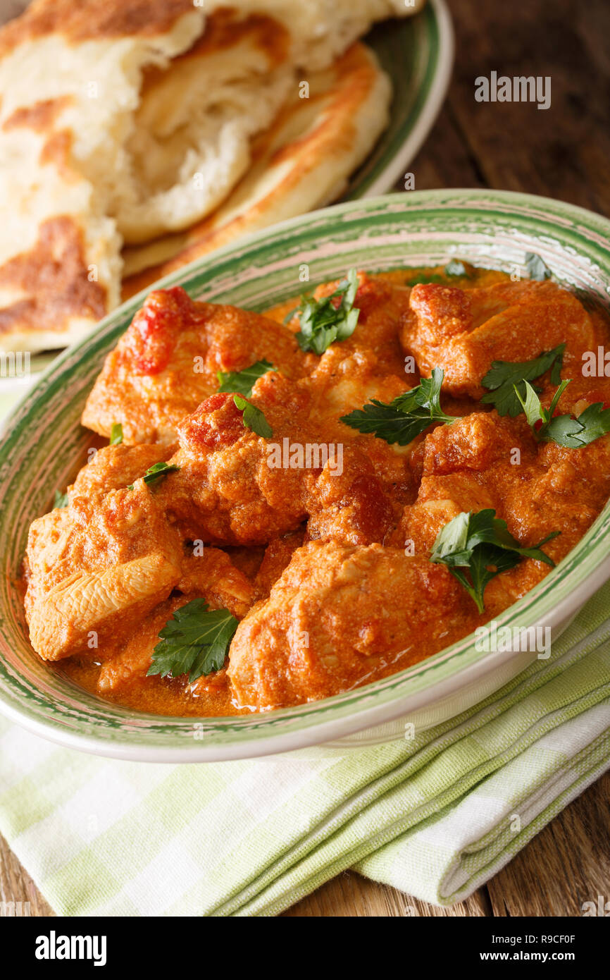 Karhai pollo in una piccante salsa di pomodoro closeup servita con pane naan su una tavola verticale. Foto Stock