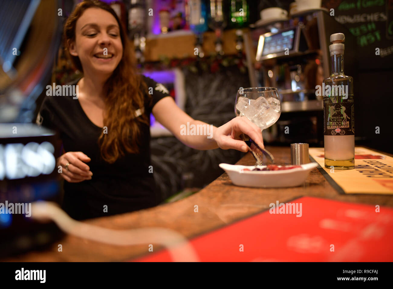 Donna che serve drink in un bar Foto Stock