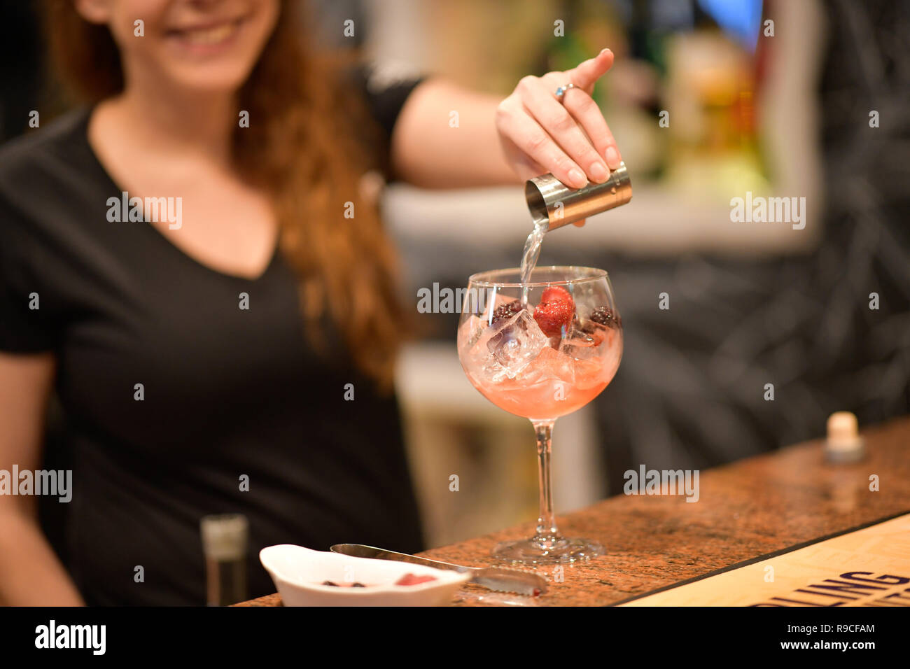 Donna che serve drink in un bar Foto Stock