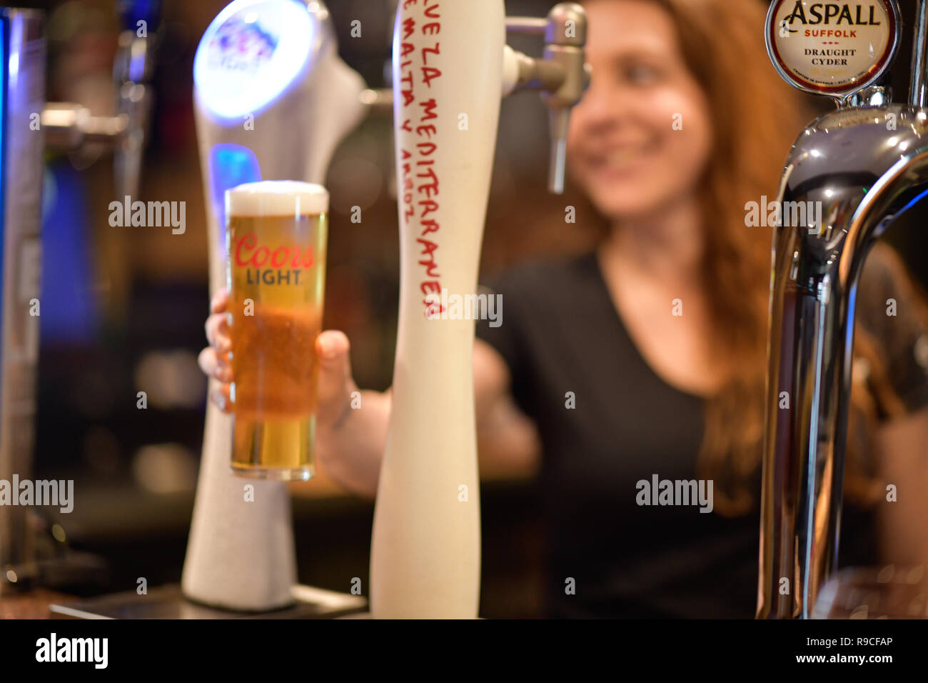Donna che serve drink in un bar Foto Stock
