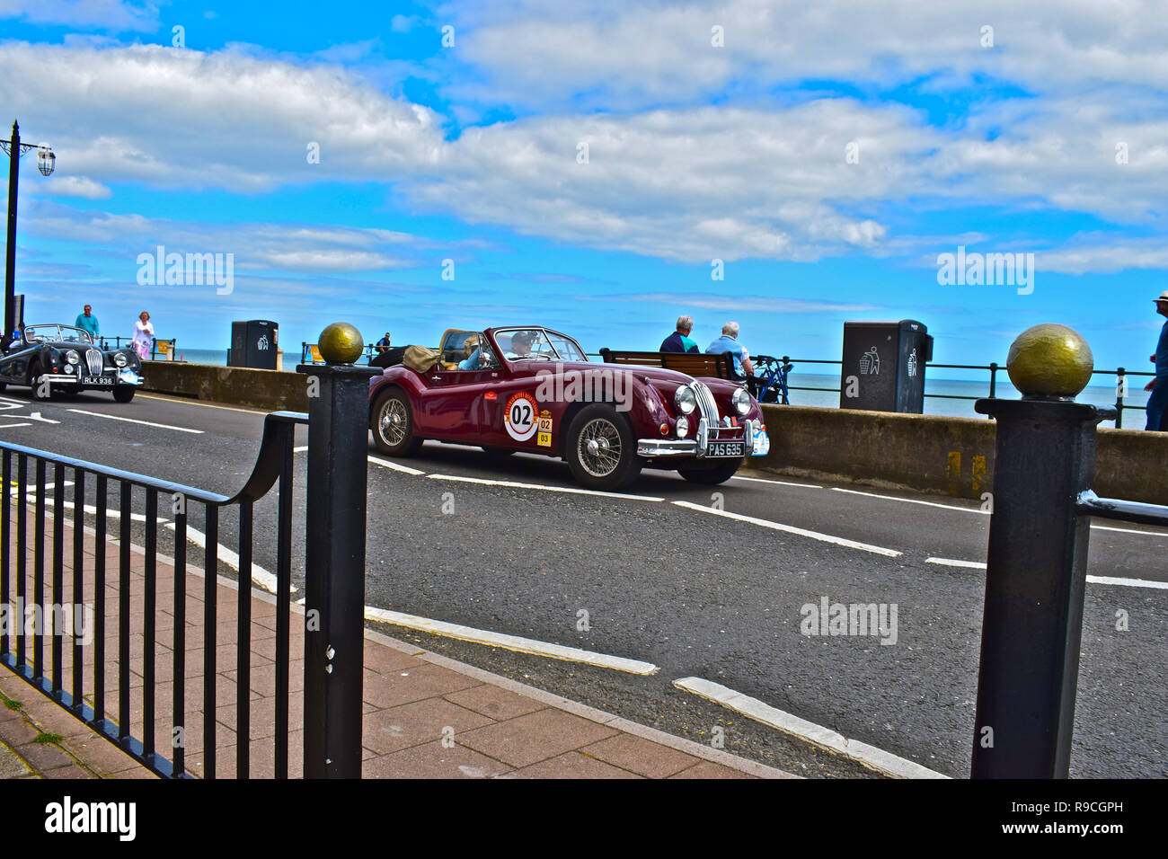 Un classico Jaguar XK120 auto sportiva trascina lungo l'esplanade a Sidmouth, pur prendendo parte al Round Britain unità costiere 12-29giugno 2017. Foto Stock