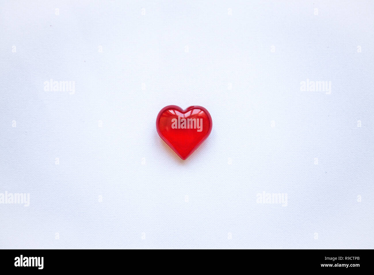 Cuore rosso su sfondo bianco. Concetto per il giorno di San Valentino o il giorno della donna o il tema della salute, la vita, la donazione e la guida in linea di . In stile minimal. Foto Stock