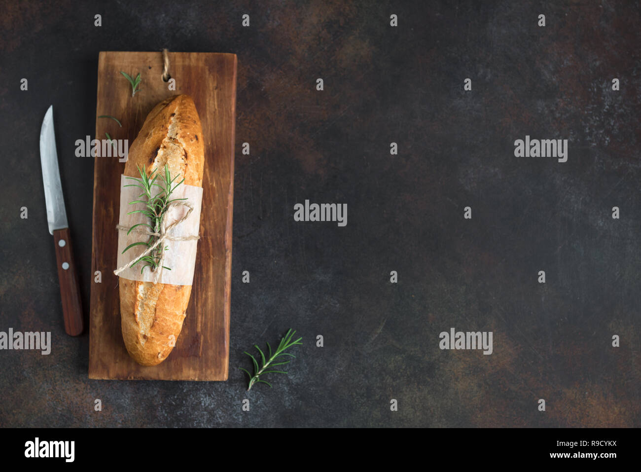Freschi Fatti in casa pane al rosmarino su sfondo rustico, vista dall'alto, copia dello spazio. Pasta madre mini baguette di pane. Foto Stock