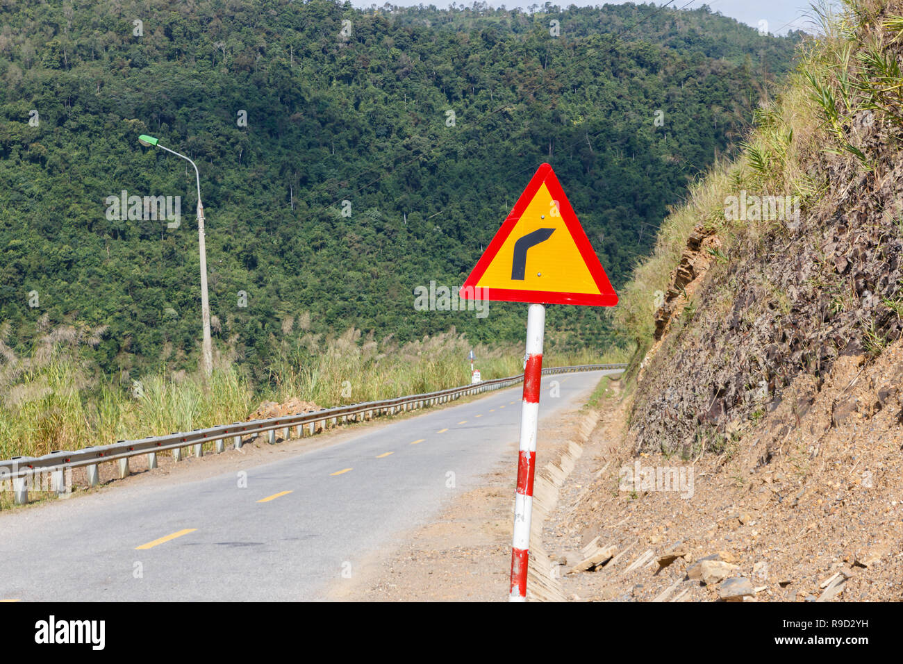 Segno pericoloso girare sulla strada di montagna Foto Stock