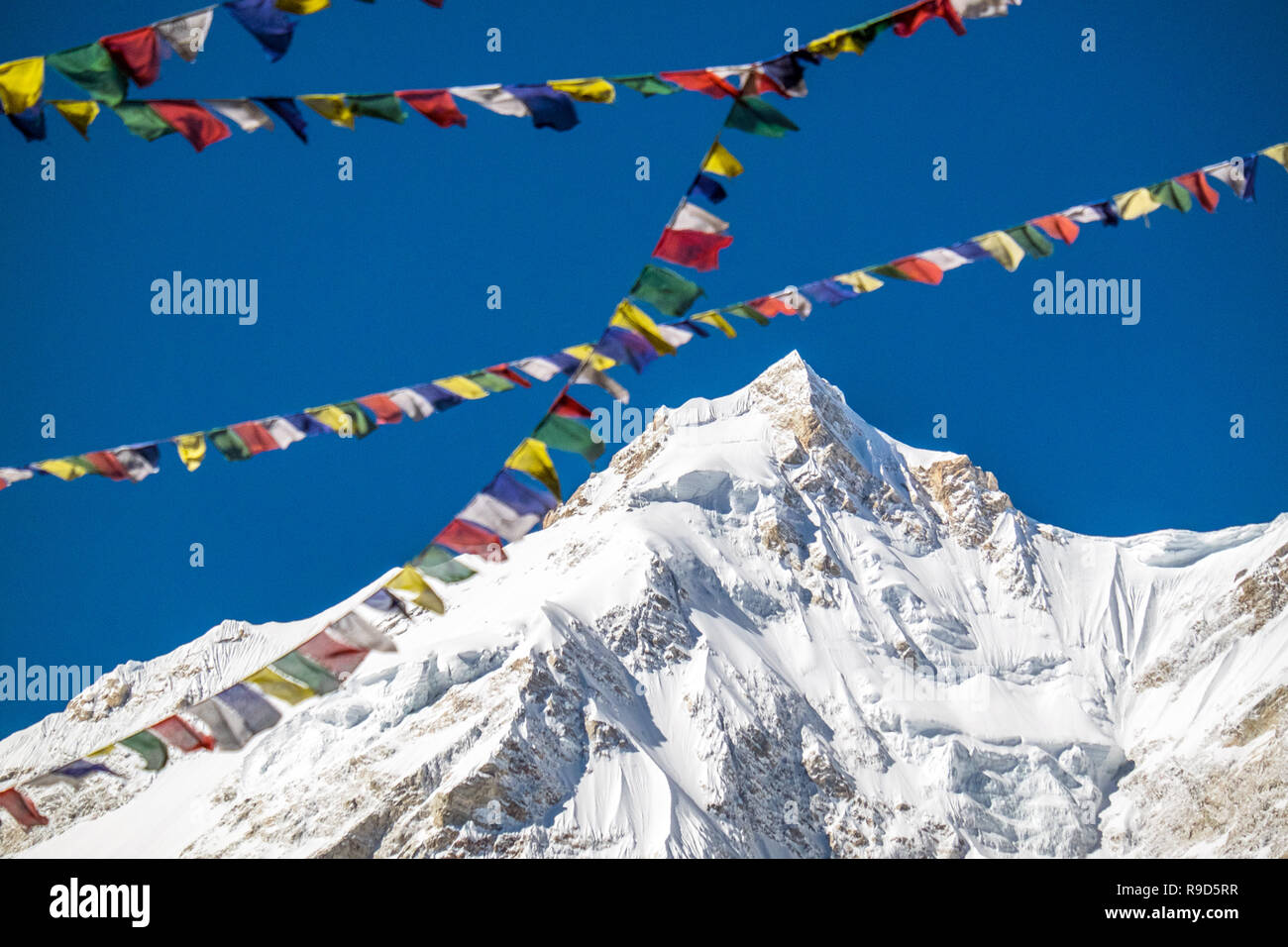 Bandiere di preghiera e il vertice di Manaslu, il mondo ottava più alta montagna, nel Nepal Himalaya Foto Stock