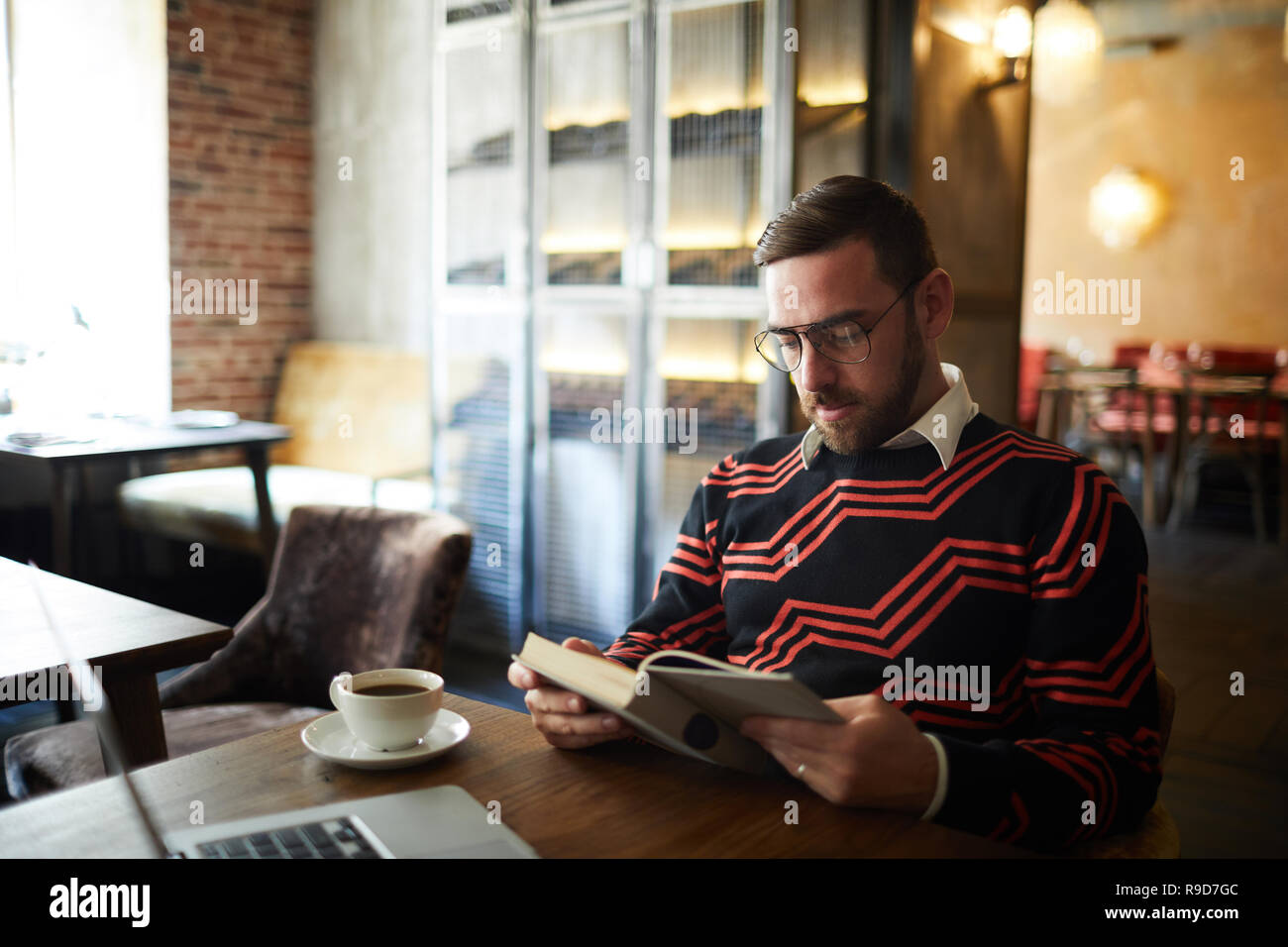 L'uomo della lettura in cafe Foto Stock