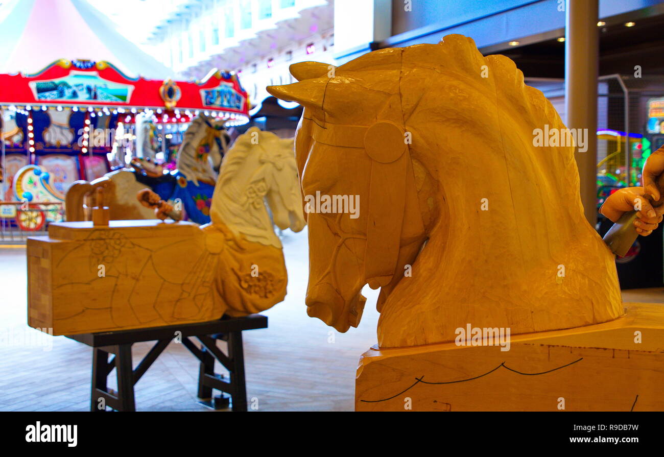 Un dipinto e coloratissima giostra cavallo in un parco di divertimenti Foto Stock