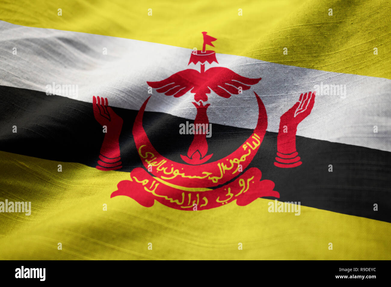 Primo piano della increspato Brunei Bandiera, Brunei bandiera soffiando nel vento Foto Stock