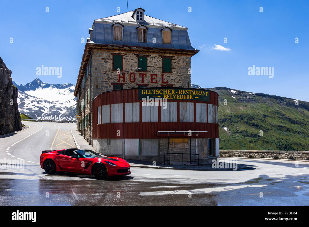 Un rosso sportcar Vicino a Hotel Belvedere sulla strada del Furka Pass, uno dei più spettacolari alpine road. Vallese, Svizzera, Luglio 2018 Foto Stock