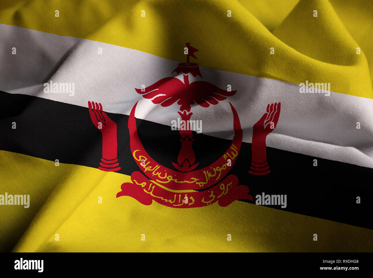 Primo piano della increspato Brunei Bandiera, Brunei bandiera soffiando nel vento Foto Stock