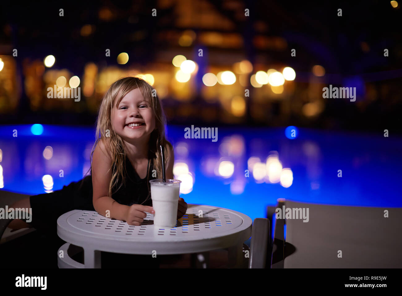 Bambina con latte cocktail in piscina Foto Stock