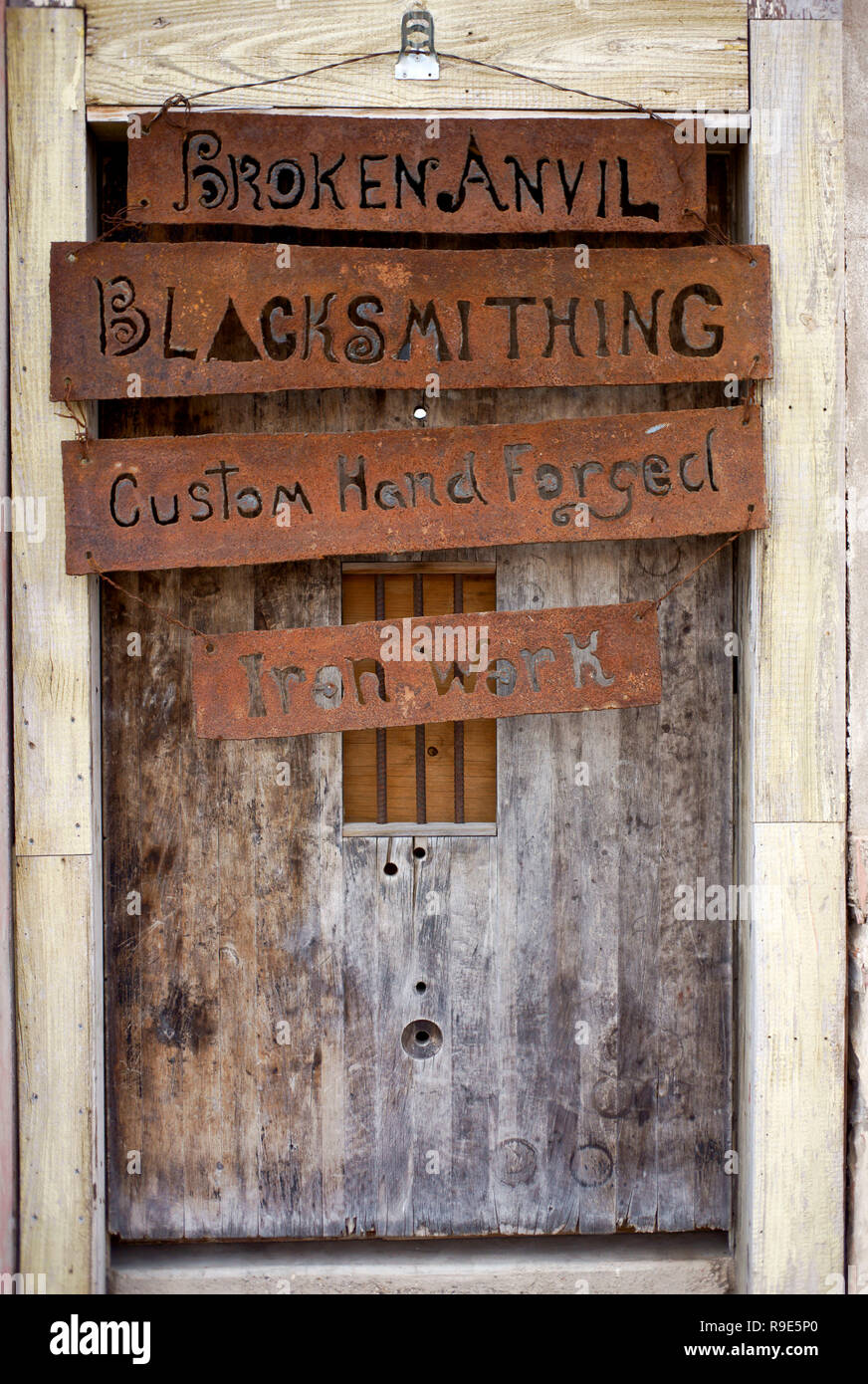 Realizzato a mano con cartelli appesi a un negozio di fabbro ferraio in Alpine, Texas Foto Stock
