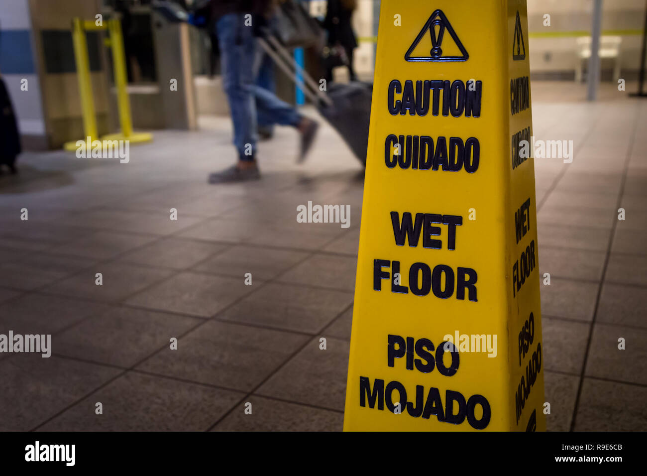 Spia gialla di attenzione scivoloso pavimento bagnato isolato di segno. Foto Stock