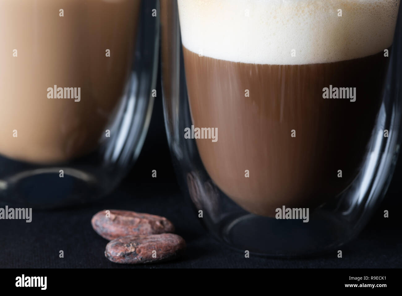 Caffè con schiuma di latte in un bicchiere con pareti doppie. Foto Stock
