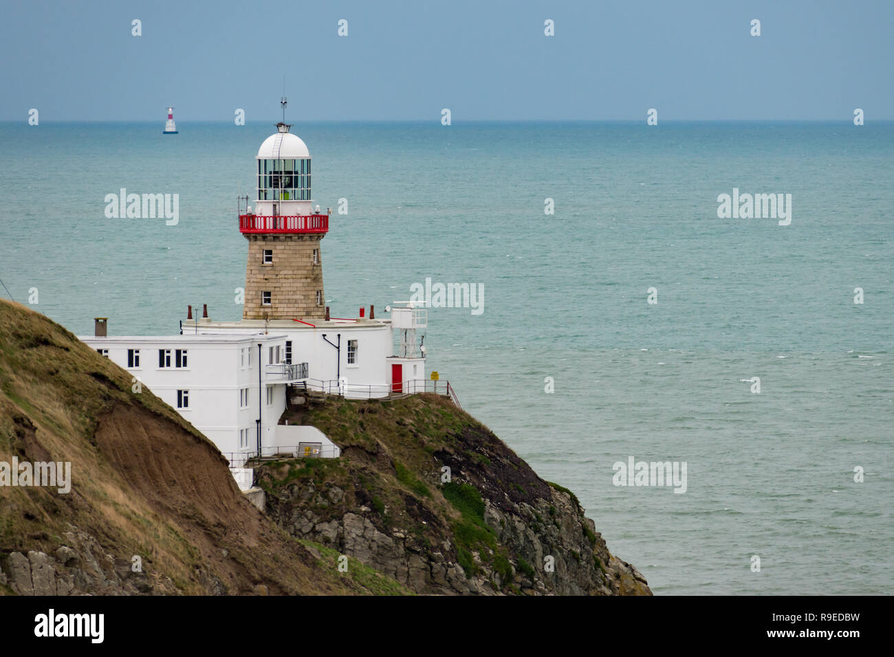 Baily Lighthouse, Dublin, Irlanda - 16 dicembre 2018: vista del faro di Baily sulla penisola di Howth scogliere con un secondo faro illuminato Foto Stock