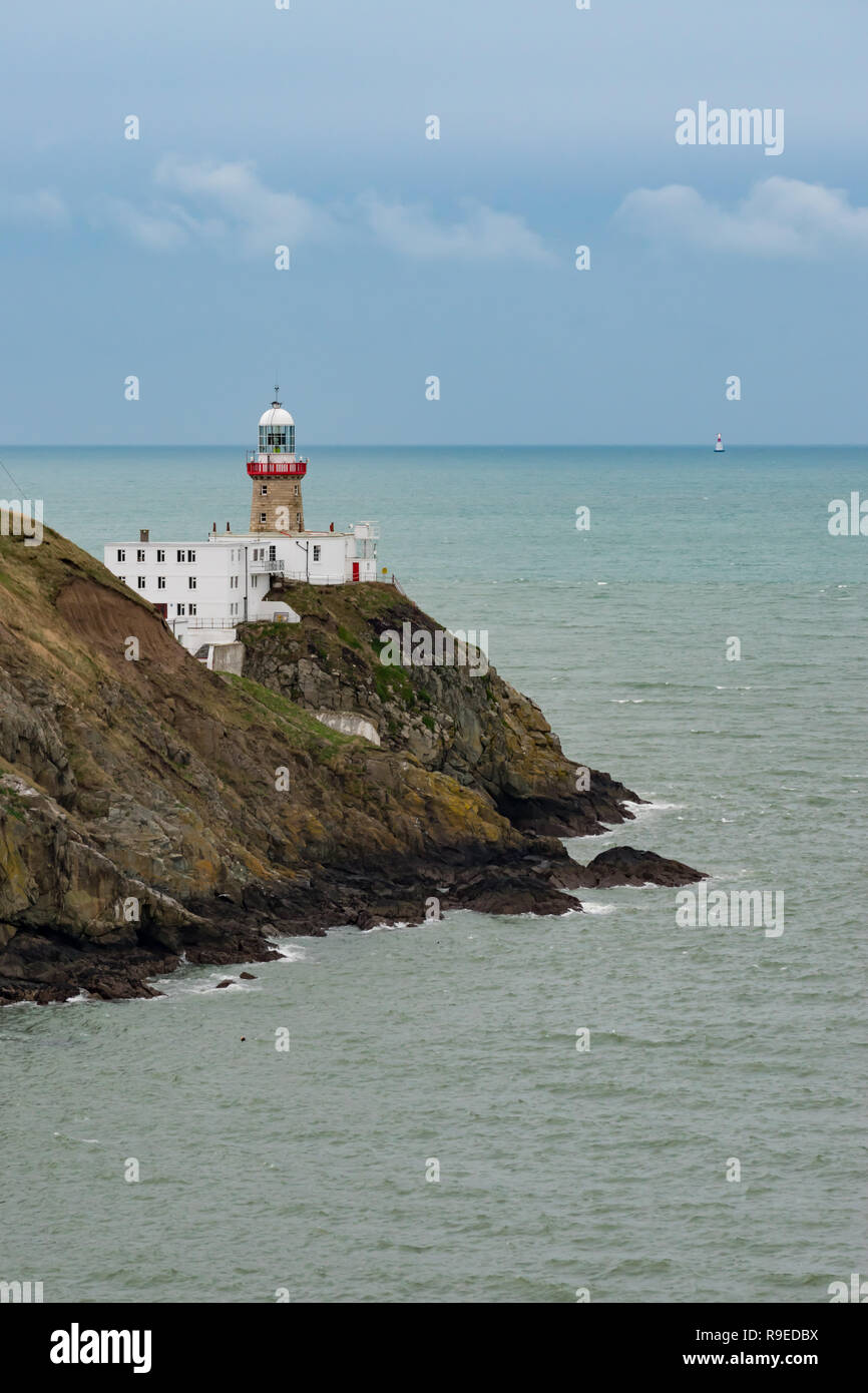 Baily Lighthouse, Dublin, Irlanda - 16 dicembre 2018: vista del faro di Baily sulla penisola di Howth scogliere con un secondo faro illuminato Foto Stock