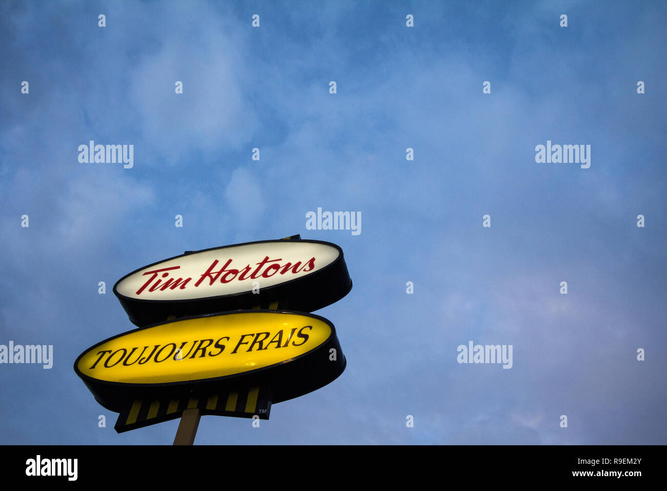 MONTREAL, Canada - 6 Novembre 2018: Tim Hortons logo nella parte anteriore di uno dei loro ristoranti in Quebec con il loro slogan in francese. Tim Hortons è un caf Foto Stock