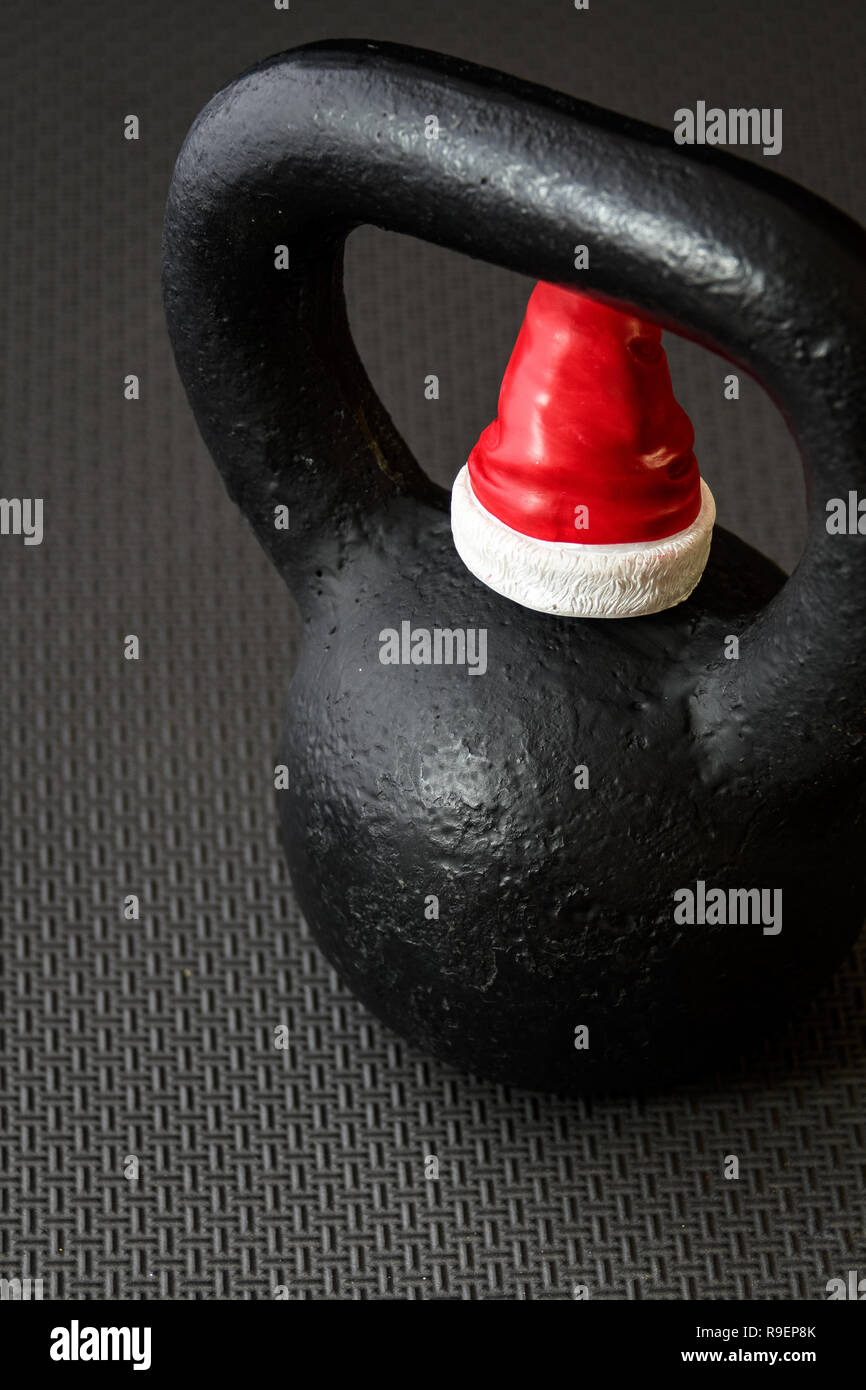 Kettlebell nero su nero pavimento Palestra con piccoli di colore rosso e  bianco Santa Claus hat a celebrare il Natale Foto stock - Alamy