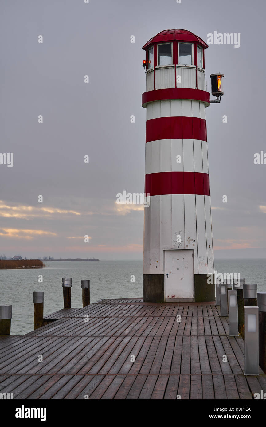 Il faro di Podersdorf alla fine di un molo di legno a Neusiedler SEE al tramonto, un punto di riferimento iconico nel Burgenland, Austria Foto Stock