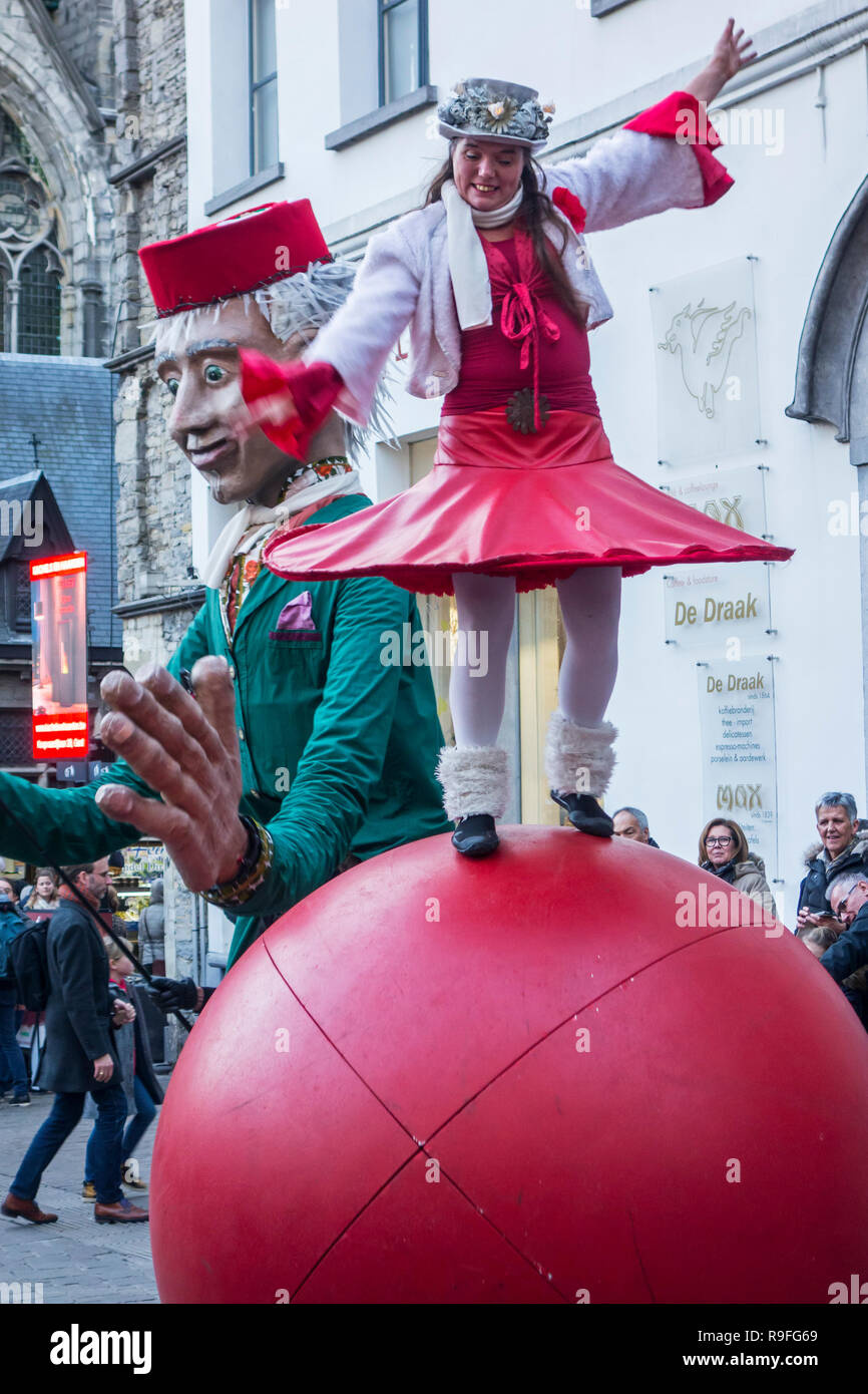 Burattinaio e street performer di eseguire il bilanciamento agisce sulla sfera gigante durante il mercatino di Natale in inverno a Gand, Fiandre, in Belgio Foto Stock