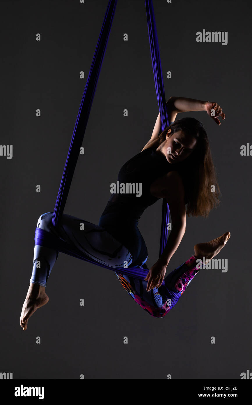 Femmina antenna posa anti-gravità yoga su una amaca Foto Stock