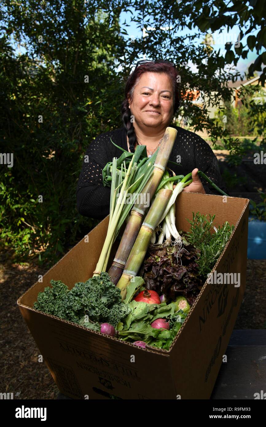 Cofondatore e Direttore Esecutivo Maria Alonso mostra un tipico CSA scatola di produzione previsto per i membri della comunità presso la comunità organica supportato il giardino e la fattoria in un basso reddito e comunità urbane Novembre 13, 2018 in Ontario, California. Gli Stati Uniti Dipartimento di Agricoltura e Risorse Naturali Servizio conservazione e Redlands District Conservazionista Tomas Aguilar-Campos lavorano a stretto contatto con le comunità locali per il supporto di prodotti biologici locali per tutti indipendentemente dal livello di reddito. Foto Stock
