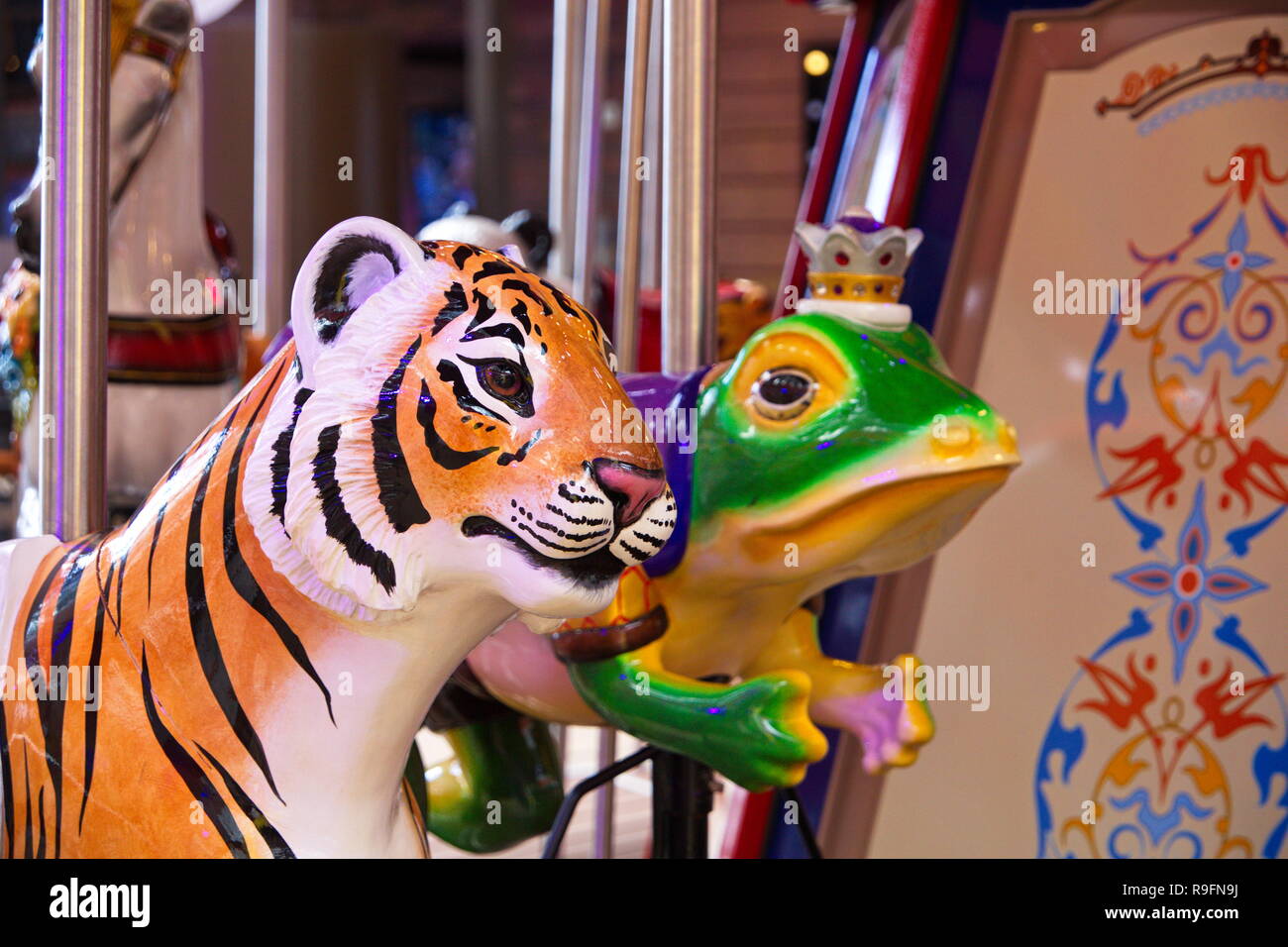 Dipinto e coloratissima giostra animali in un parco di divertimenti Foto Stock