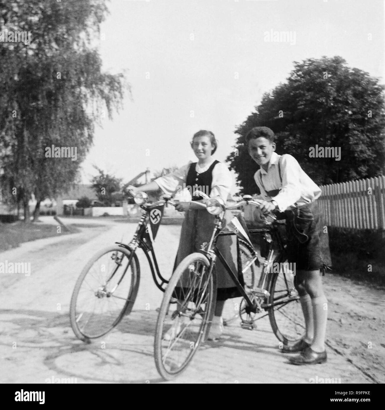 Due adolescenti mostrare con orgoglio le bandiere nazionali sulle loro moto in pre-guerra in Germania, ca. 1935. Foto Stock