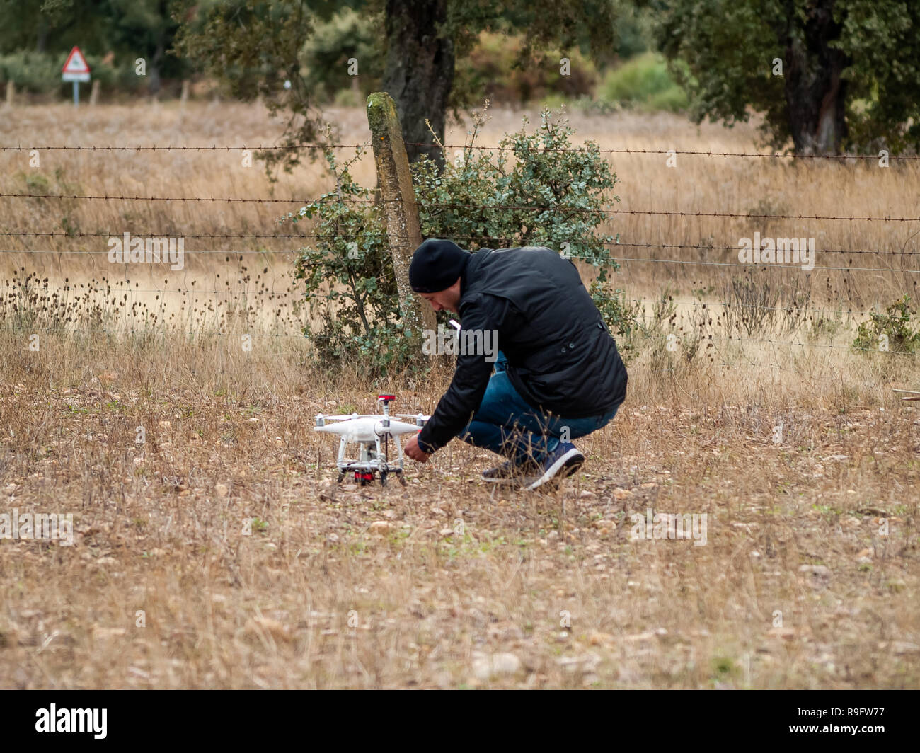 Un drone pilota configurando il suo drone nella foresta prima di volare Foto Stock