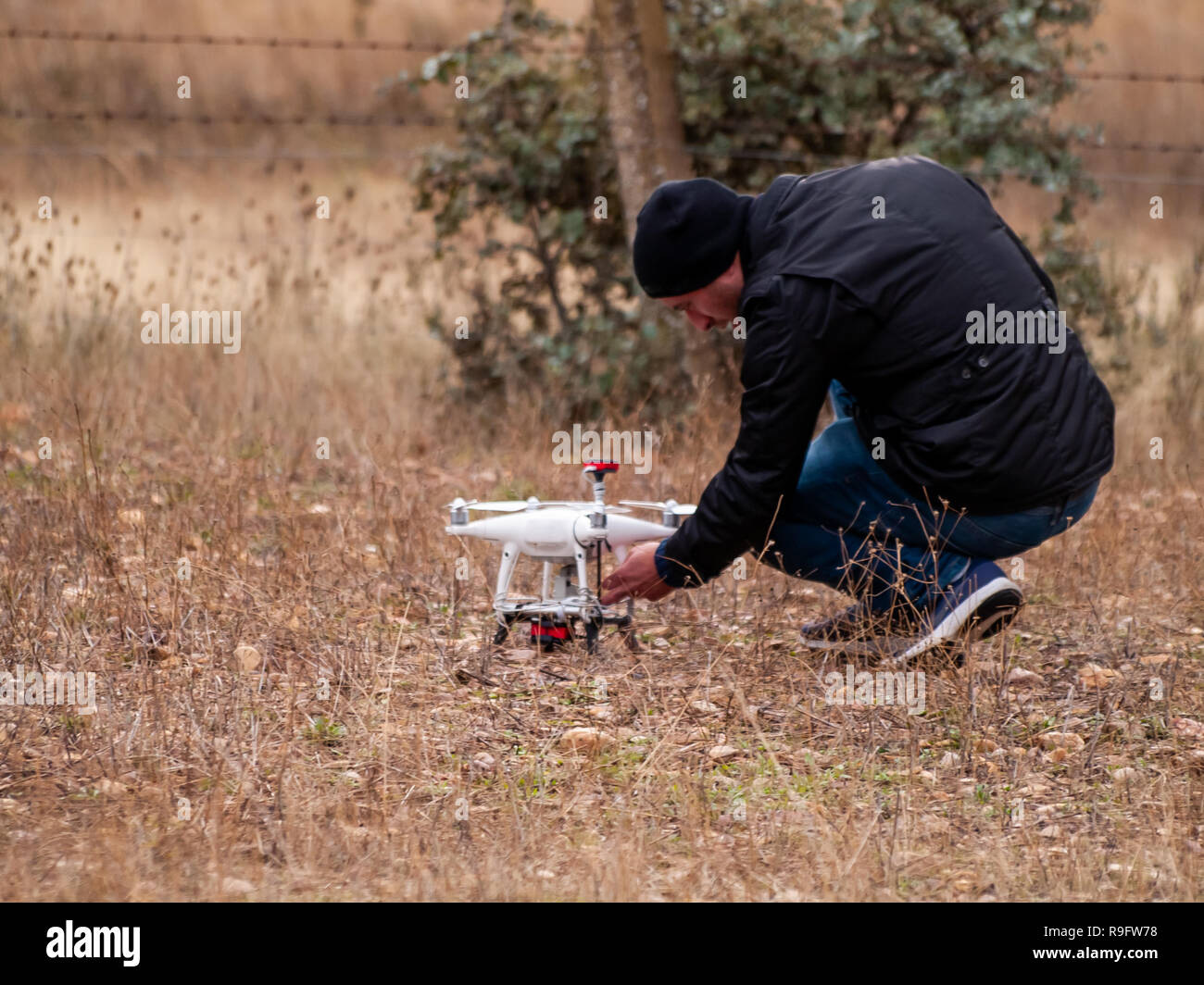 Un drone pilota configurando il suo drone nella foresta prima di volare Foto Stock