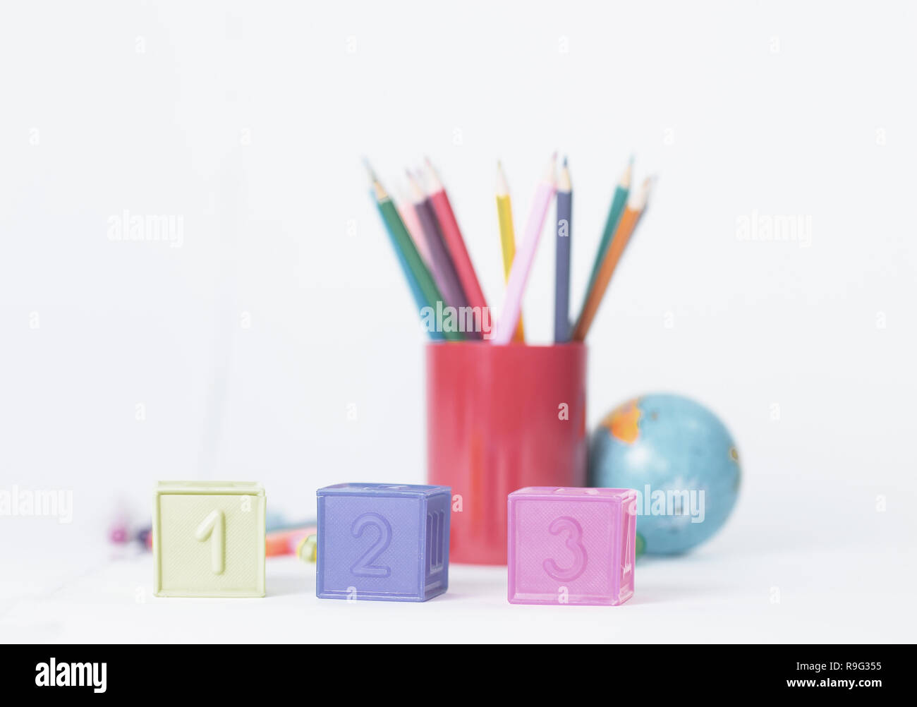 A cubetti con i numeri sulla scuola sfocata sullo sfondo dei materiali di consumo Foto Stock