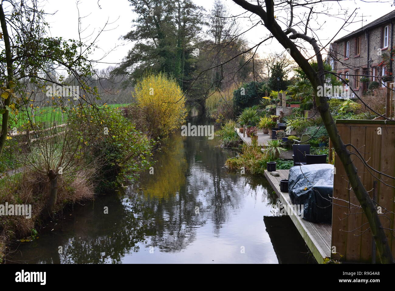 Attraversando il fiume Darenth (talvolta Darent farro), una trota torrente, vicino Mill Lane a Shoreham, Kent. Incantevoli giardini dal fiume. I primi di dicembre. Foto Stock