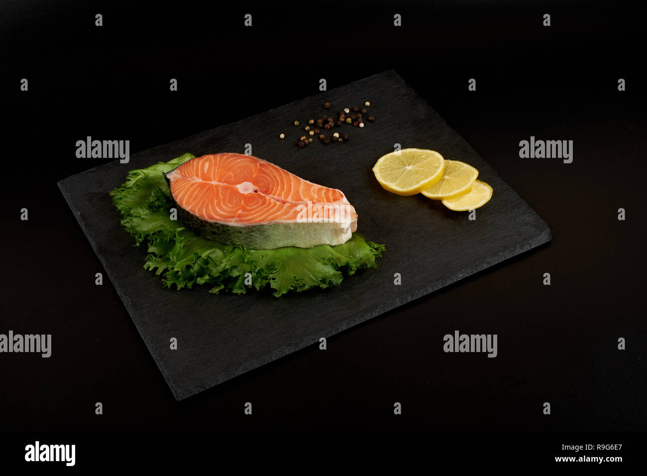 Raw bistecca di salmone e spezie sulla piastra di ardesia pronti per la cottura Foto Stock