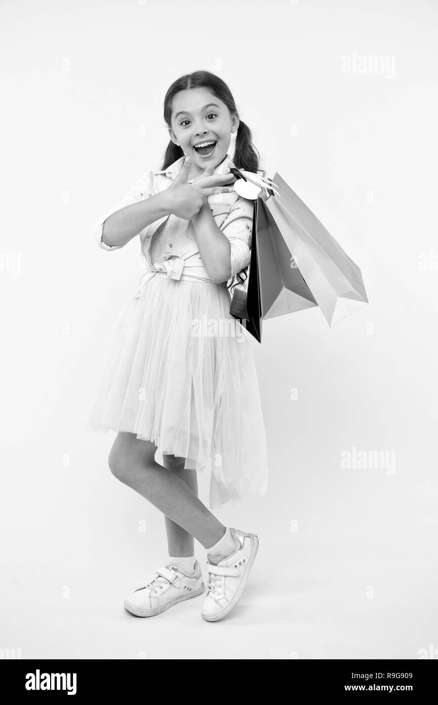Shopping bag a bambino. bambino con shopping bag. purchse insedi di shopping bag in mano di capretto. Felice ragazza con shopping bag. Guardate cosa ottengo Foto Stock