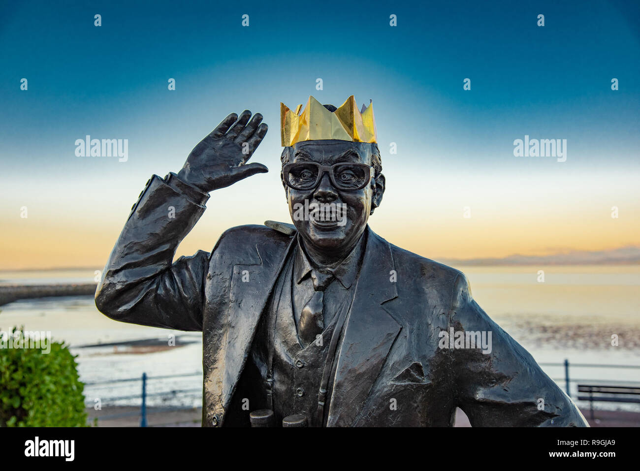 Un tramonto dopo una bella ma fredda giornata a Morecambe, LancashireSomeone ha aggiunto una corona d'oro per la statua di Eric Morecambe nella sua città natale di Morecambe, Lancashire alla vigilia di Natale. Con il suo partner, Ernie Wise, egli era il re della TV con oltre 27 milioni di spettatori a guardare uno dei Morecambe e saggio mostra di Natale. Credito: John Eveson/Alamy Live News Credito: John Eveson/Alamy Live News Foto Stock