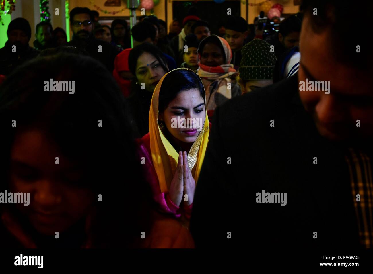Srinagar, India. 25 Dic, 2018. Un cristiano del Kashmir prega all'interno della Santa Famiglia Chiesa cattolica in occasione del Natale a Srinagar, Indiano Kashmir amministrato. In mezzo a un freddo pungente in onda lo stato, la comunità cristiana della valle di martedì ha celebrato il Natale; il giorno della nascita di Gesù Cristo, con la scorza e allegria a Srinagar. Tra quelli che hanno pregato erano i turisti provenienti da diverse parti del paese che hanno aderito alla gente del posto per il giorno fausto e pregato per la pace in Kashmir e del resto del mondo. Credito: SOPA Immagini limitata/Alamy Live News Foto Stock