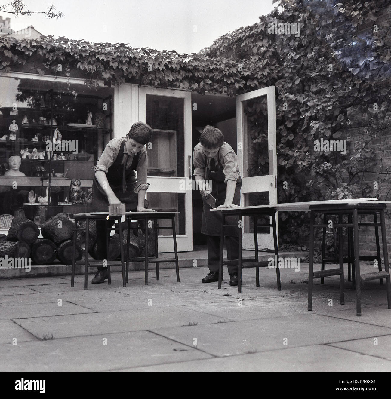1968, Londra sud,a ragazzi all interno della città Boarding School, Inghilterra, due scolari facendo lavori in legno all'esterno sul patio, Inghilterra, Regno Unito. Foto Stock