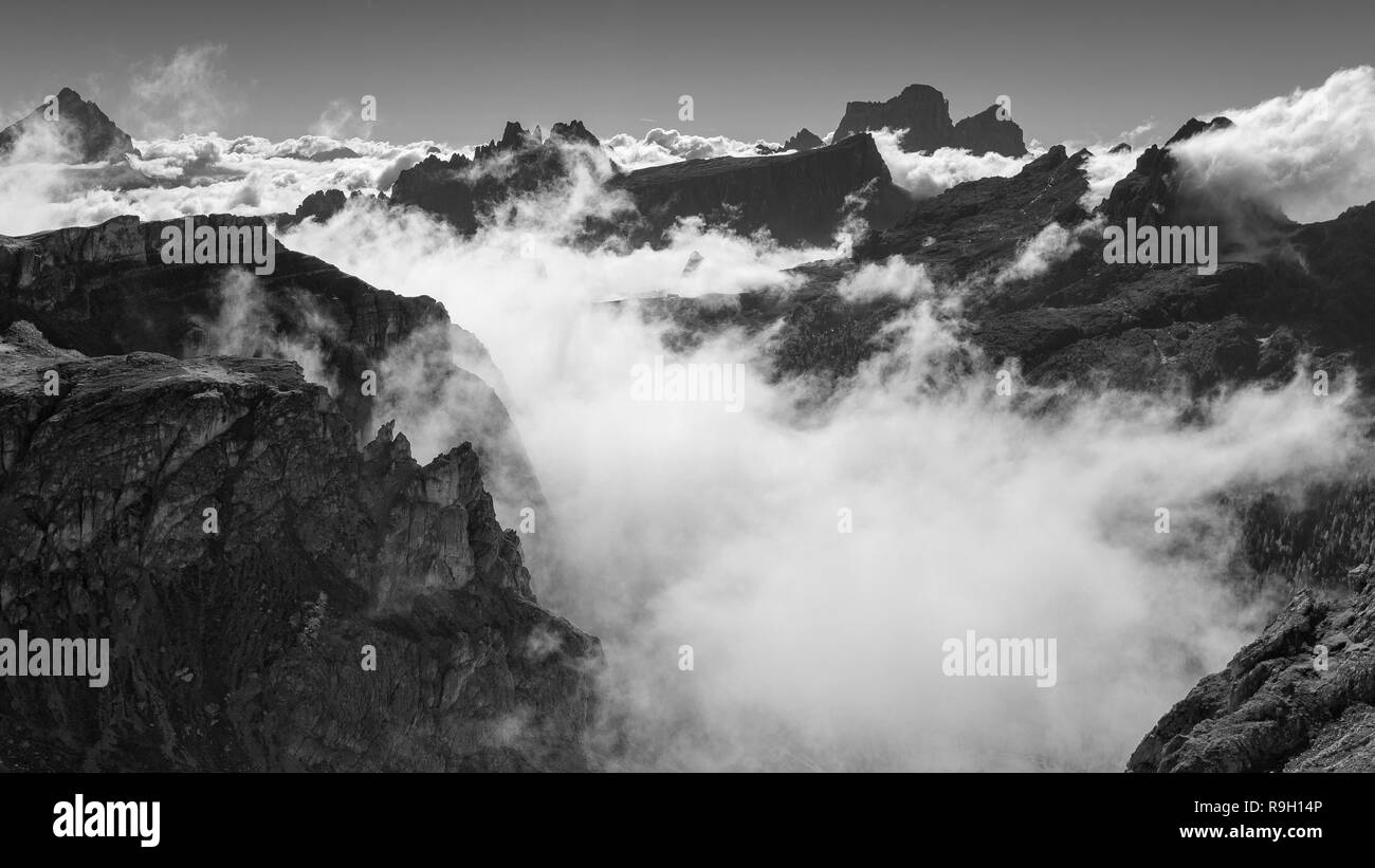Le nuvole in movimento sul passo di Falzarego. Le Dolomiti di Ampezzo. Alpi Italiane. Veneto. Europa. Paesaggio di montagna bianco nero. Foto Stock