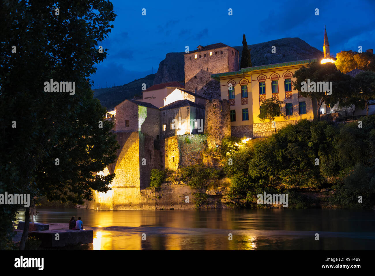 Vista notturna di case lungo il fiume Neretva, Mostar Bosnia ed Erzegovina Foto Stock
