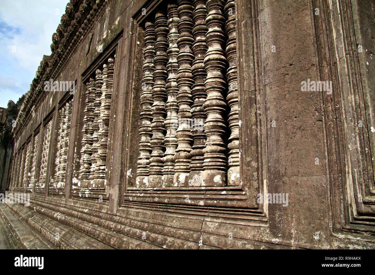 Pietra lunga parete scolpita in alcune rovine in Cambogia Foto Stock
